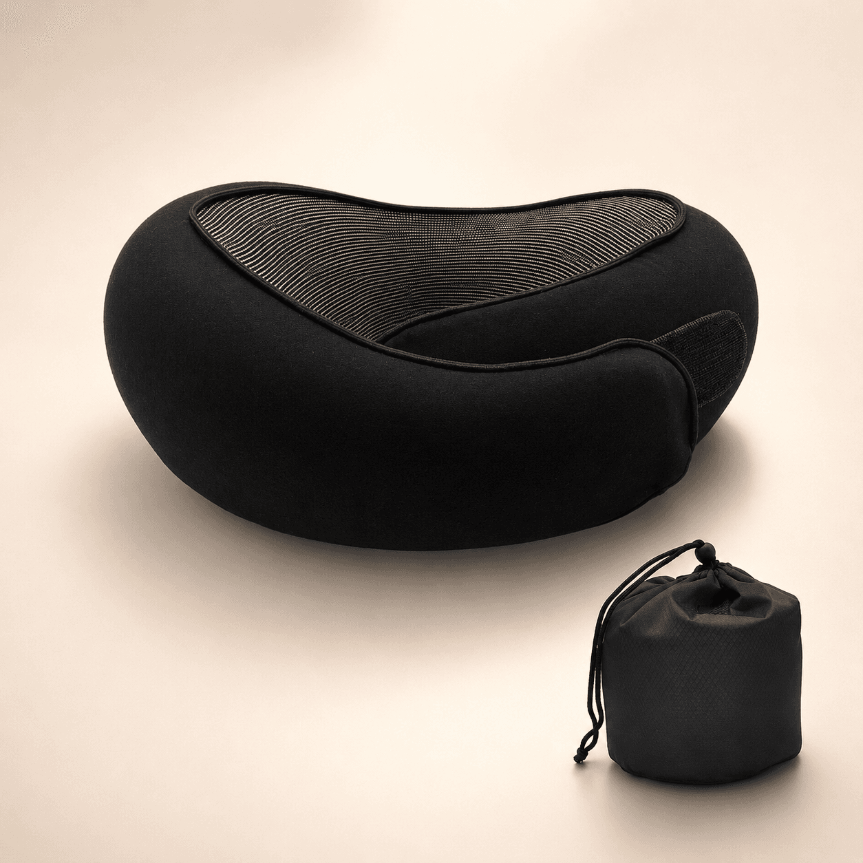 Oreiller de voyage Dodow Pillow coloris noir, posé avec sa pochette de transport assortie sur un fond beige chaud.